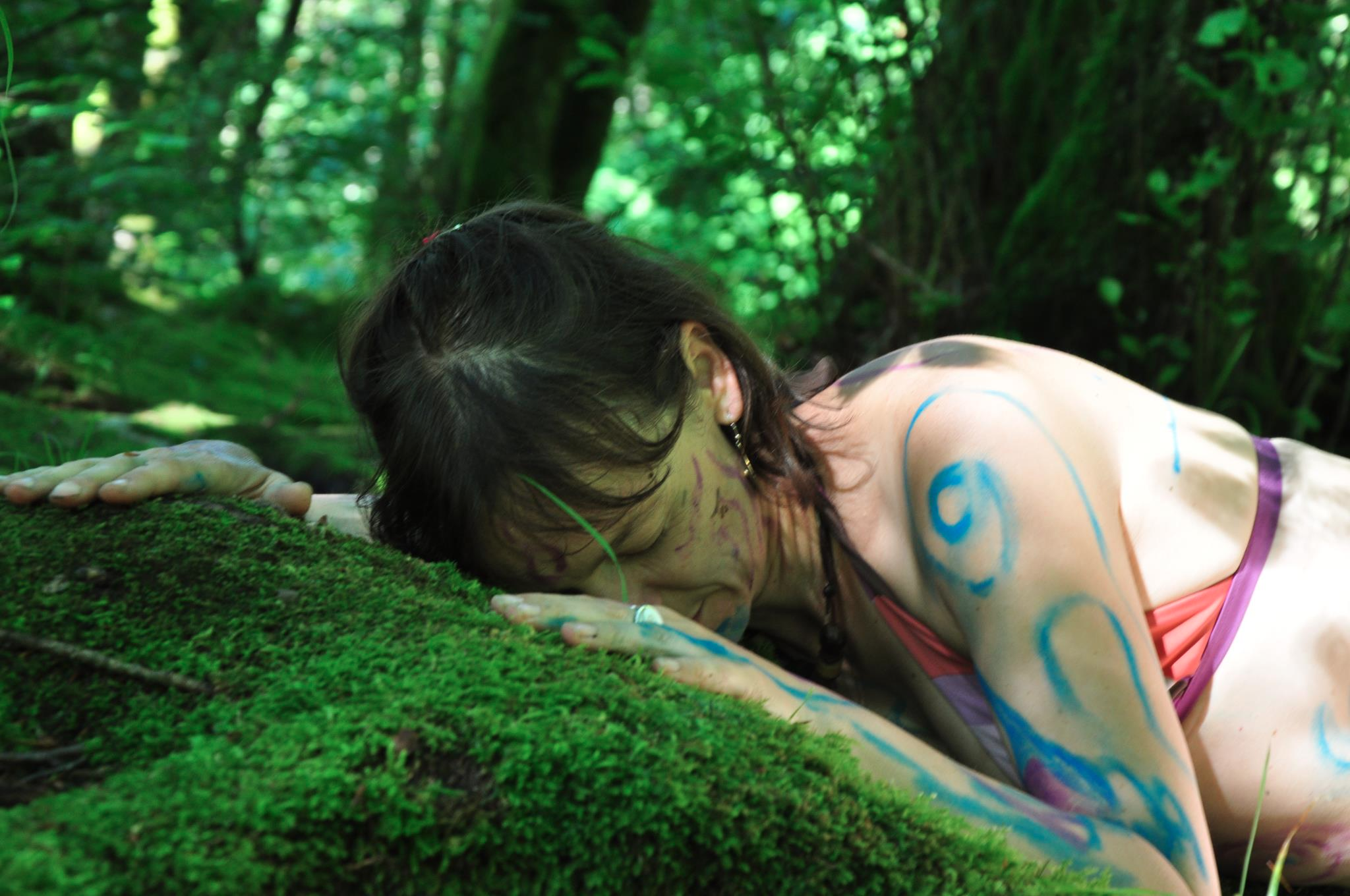 une femme allongée sur le sol de la forêt profite de la nature