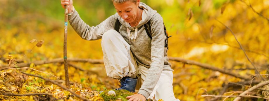 une femme touche le sol dans la forêt