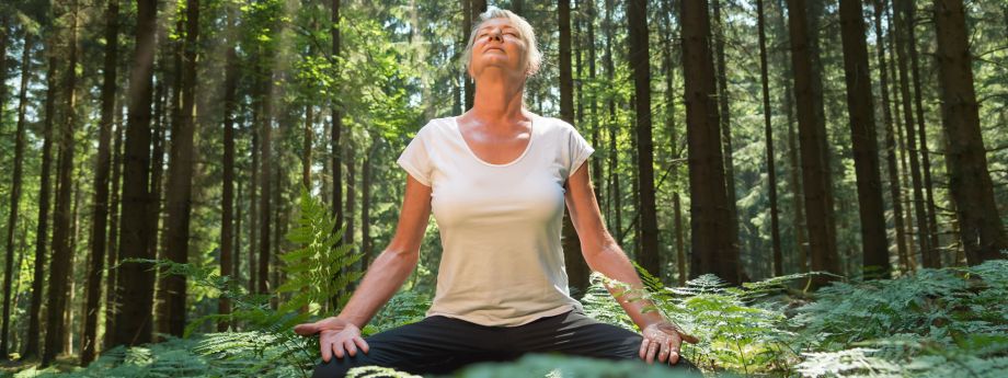 une femme médite dans la forêt